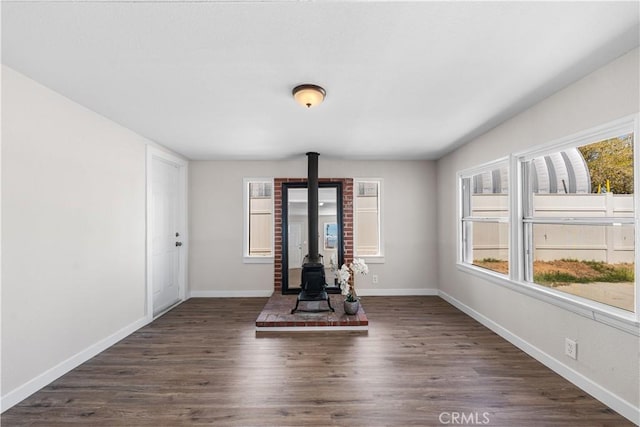 38881 Sage Tree St, Palmdale, CA 93551 - workout room with a wood stove, baseboards, and dark wood finished floors