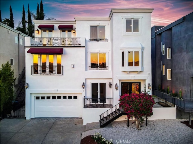 5250 Calatrana Dr, Woodland Hills, CA 91364 - view of front of home with a balcony, stucco siding, driveway, and a garage