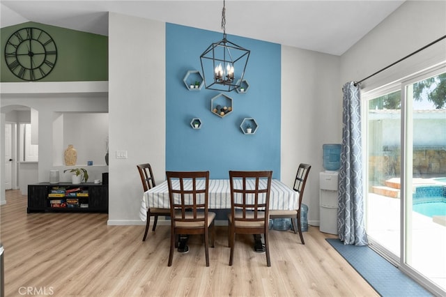 13797 Mesquite Dr, Fontana, CA 92337 - dining area featuring a chandelier, wood finished floors, arched walkways, baseboards, and lofted ceiling