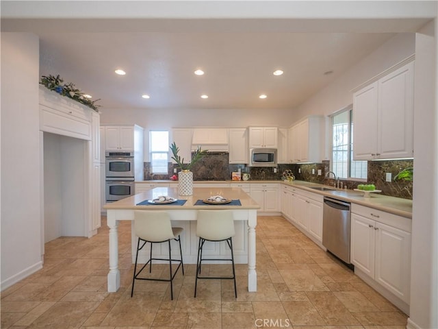 8365 Sanctuary Dr, Corona, CA 92883 - kitchen with stainless steel appliances, backsplash, a sink, white cabinetry, and recessed lighting