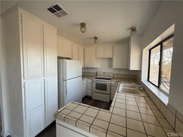 3874 Kreuer Rd, Phelan, CA 92371 - kitchen featuring white appliances, tile counters, a sink, and white cabinetry