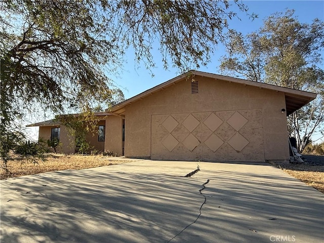 3874 Kreuer Rd, Phelan, CA 92371 - view of front of home with stucco siding, driveway, and an attached garage
