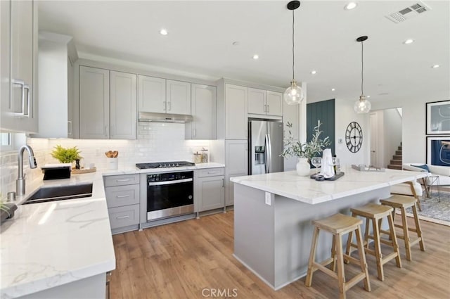 41847 Oak Barrel Ct, Palmdale, CA 93551 - kitchen with stainless steel appliances, a sink, tasteful backsplash, light wood-style floors, and recessed lighting