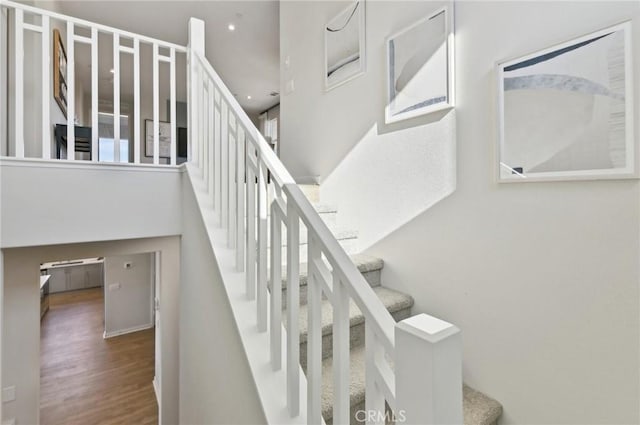 41847 Oak Barrel Ct, Palmdale, CA 93551 - staircase featuring wood finished floors, a towering ceiling, and recessed lighting