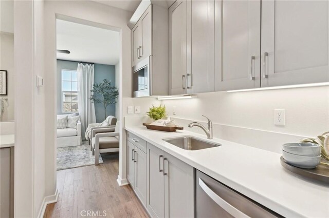 41847 Oak Barrel Ct, Palmdale, CA 93551 - kitchen featuring a sink, light wood-type flooring, dishwasher, light countertops, and gray cabinets
