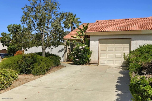 1604 Woodrum Pl, El Cajon, CA 92019 - mediterranean / spanish-style home with driveway, stucco siding, a tile roof, and an attached garage