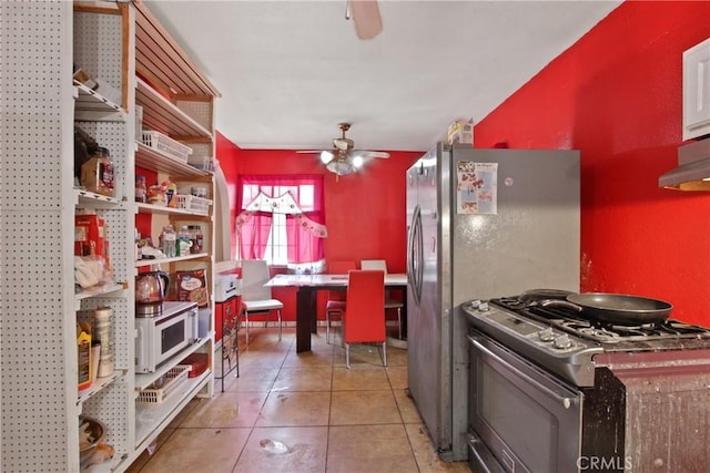 213 N Figueroa St, Santa Ana, CA 92703 - kitchen featuring gas stove, white microwave, ceiling fan, tile patterned floors, and under cabinet range hood