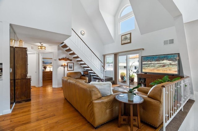 374 Orange Ave Unit F, Coronado, CA 92118 - living area with high vaulted ceiling, stairway, wood finished floors, and baseboards