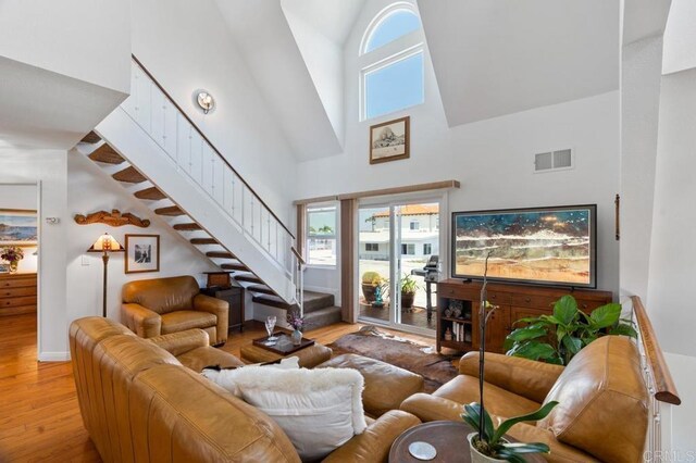 374 Orange Ave Unit F, Coronado, CA 92118 - living area featuring high vaulted ceiling, hardwood / wood-style flooring, stairway, and baseboards