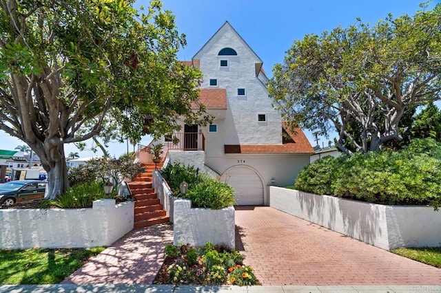 374 Orange Ave Unit F, Coronado, CA 92118 - view of front of house featuring stucco siding, stairway, decorative driveway, and a garage