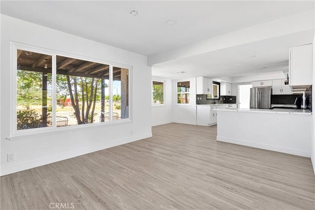 14855 Flathead Rd, Apple Valley, CA 92307 - unfurnished living room with light wood finished floors, baseboards, and a sink