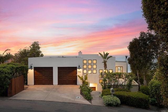 7784 Lookout Dr, La Jolla, CA 92037 - contemporary home with a garage, driveway, stucco siding, and a chimney