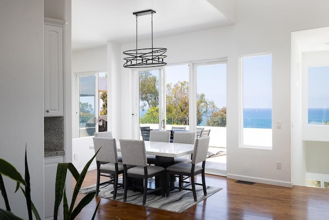 7784 Lookout Dr, La Jolla, CA 92037 - dining space with dark wood-style floors, a chandelier, and baseboards