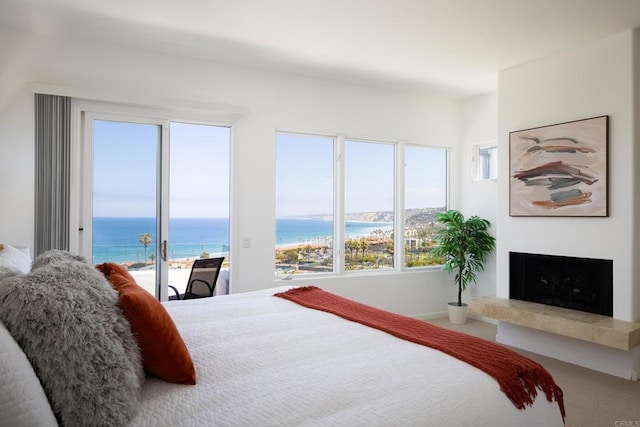 7784 Lookout Dr, La Jolla, CA 92037 - carpeted bedroom with access to exterior, a tile fireplace, multiple windows, and a water view
