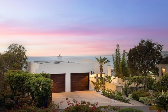 7784 Lookout Dr, La Jolla, CA 92037 - view of front of house with stucco siding, driveway, a garage, and a chimney