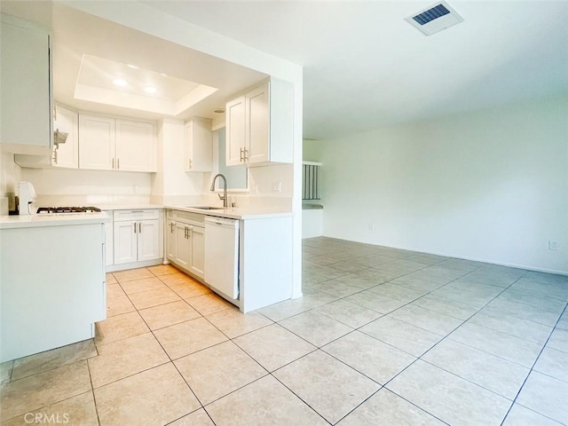 17081 Green Ln, Huntington Beach, CA 92649 - kitchen with dishwasher, a sink, a tray ceiling, white cabinetry, and light tile patterned flooring
