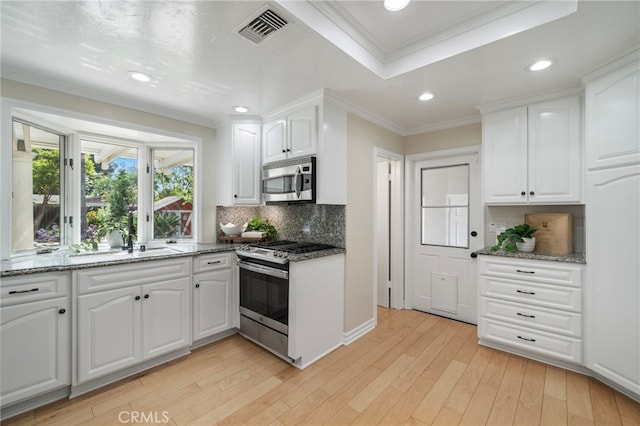 13782 Gershon Pl, North Tustin, CA 92705 - kitchen featuring stainless steel appliances, ornamental molding, white cabinets, backsplash, and dark stone countertops