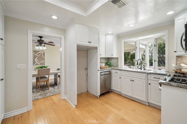 13782 Gershon Pl, North Tustin, CA 92705 - kitchen featuring stainless steel appliances, decorative backsplash, white cabinetry, light wood-style floors, and dark stone countertops