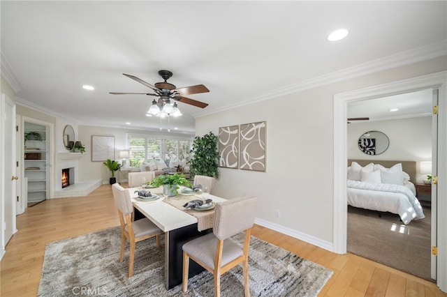 13782 Gershon Pl, North Tustin, CA 92705 - dining space featuring light wood-style floors, a ceiling fan, recessed lighting, ornamental molding, and a brick fireplace