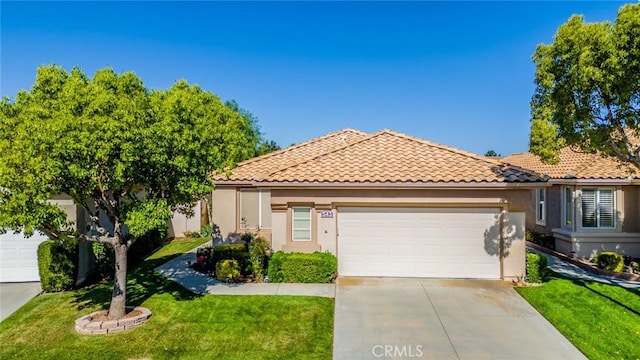 543 Northwood Ave, Banning, CA 92220 - mediterranean / spanish-style house featuring concrete driveway, a garage, a front yard, a tiled roof, and stucco siding