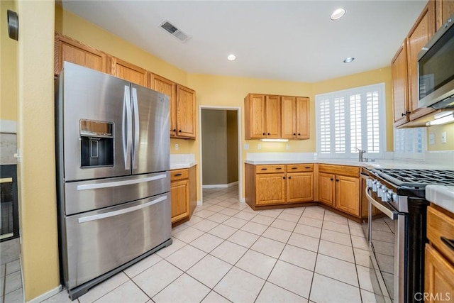 543 Northwood Ave, Banning, CA 92220 - kitchen featuring appliances with stainless steel finishes, light countertops, light tile patterned flooring, recessed lighting, and baseboards