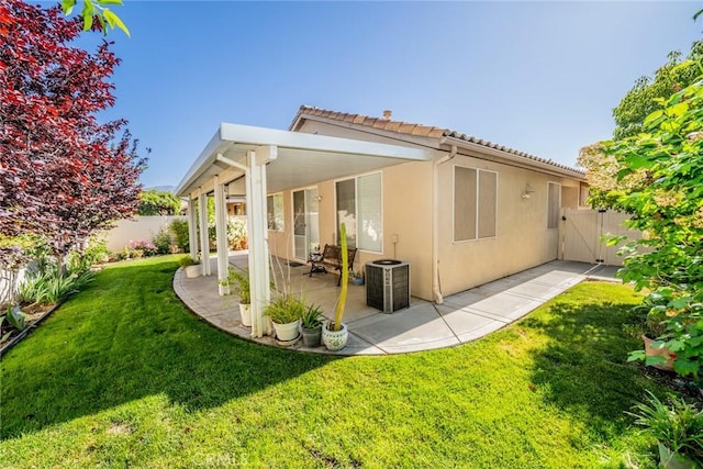 543 Northwood Ave, Banning, CA 92220 - back of house featuring a patio area, stucco siding, central AC, a tiled roof, and a gate