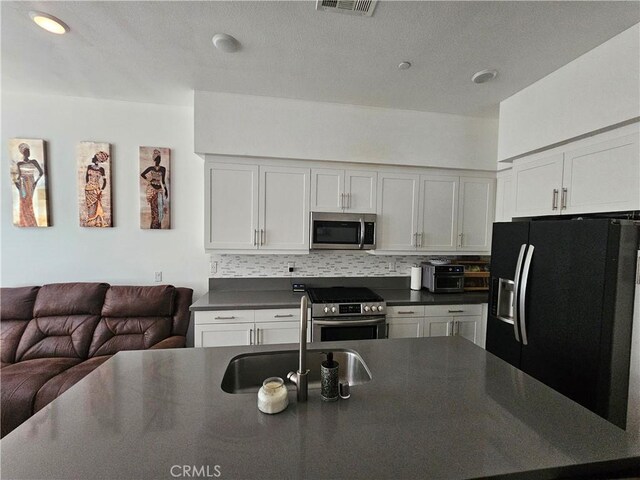 10402 Harlow Cir Unit 41, San Diego, CA 92108 - kitchen featuring stainless steel appliances, a sink, dark countertops, and open floor plan