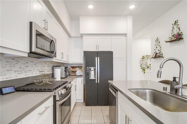 10402 Harlow Cir Unit 41, San Diego, CA 92108 - kitchen with appliances with stainless steel finishes, light tile patterned floors, white cabinets, tasteful backsplash, and recessed lighting