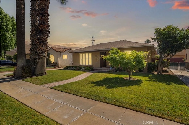 3055 N Arrowhead Ave, San Bernardino, CA 92405 - view of front facade featuring stucco siding and a lawn