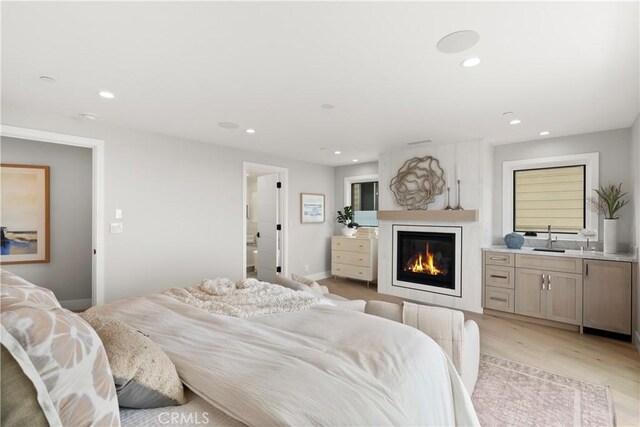 2141 Circle Dr, Hermosa Beach, CA 90254 - bedroom featuring a sink, a glass covered fireplace, recessed lighting, and light wood-style flooring