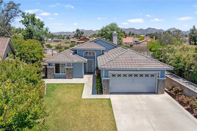 32725 Trailwood Ct, Wildomar, CA 92595 - view of front of house with stone siding, a garage, a mountain view, driveway, and a tiled roof