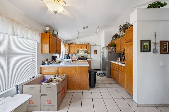 32725 Trailwood Ct, Wildomar, CA 92595 - kitchen with appliances with stainless steel finishes, a peninsula, lofted ceiling, brown cabinetry, and ceiling fan