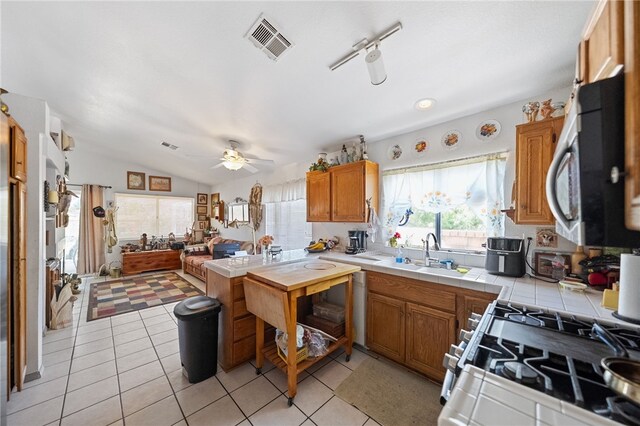 32725 Trailwood Ct, Wildomar, CA 92595 - kitchen with gas stove, a sink, tile countertops, stainless steel microwave, and ceiling fan