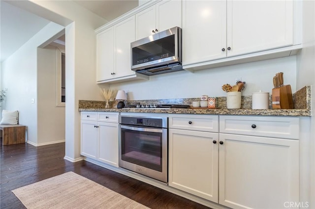 29590 Rawlings Way, Lake Elsinore, CA 92530 - kitchen with stainless steel appliances, white cabinetry, dark wood-type flooring, dark stone countertops, and baseboards