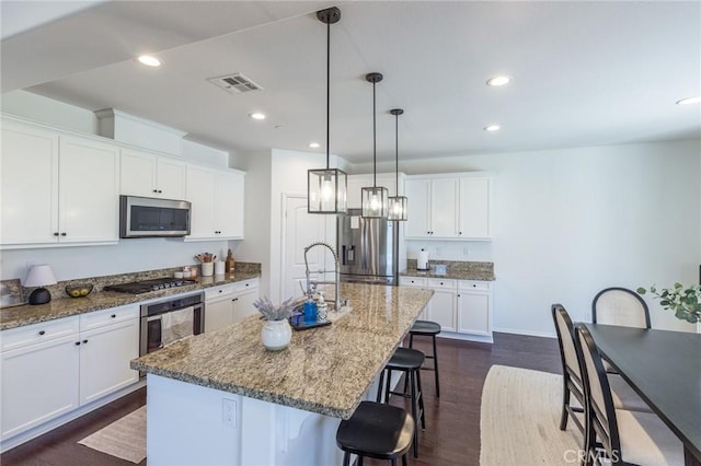 29590 Rawlings Way, Lake Elsinore, CA 92530 - kitchen with stainless steel appliances, a kitchen bar, a sink, dark wood-style flooring, and recessed lighting