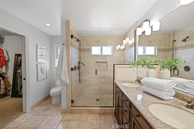 2662 Salmon Dr, Los Alamitos, CA 90720 - bathroom featuring a shower stall, double vanity, toilet, baseboards, and a walk in closet