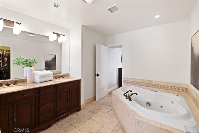 2662 Salmon Dr, Los Alamitos, CA 90720 - bathroom featuring double vanity, a jetted tub, recessed lighting, and stone tile flooring