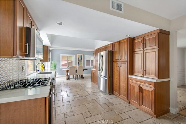 2662 Salmon Dr, Los Alamitos, CA 90720 - kitchen with stainless steel fridge with ice dispenser, a sink, baseboards, stone tile flooring, and tasteful backsplash