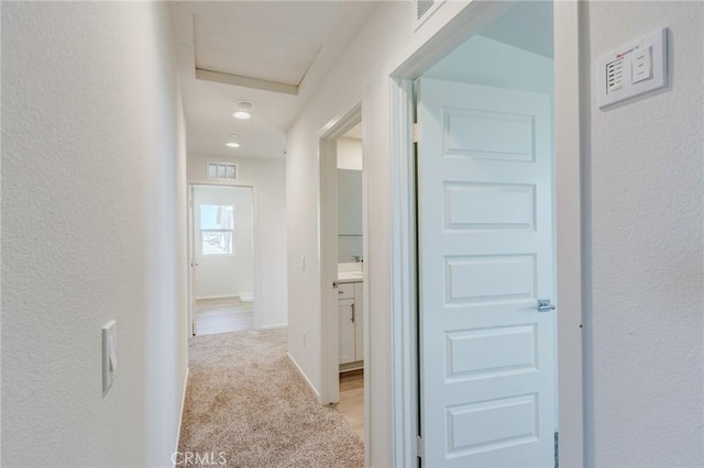 13119 Lancaster St, Hesperia, CA 92344 - corridor featuring light carpet, a textured wall, and baseboards