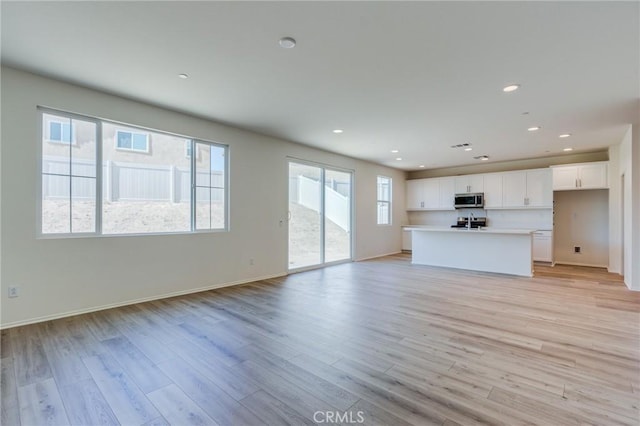 13119 Lancaster St, Hesperia, CA 92344 - unfurnished living room featuring light wood-type flooring, recessed lighting, and baseboards