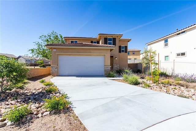 13119 Lancaster St, Hesperia, CA 92344 - mediterranean / spanish house featuring stone siding, stucco siding, an attached garage, a tile roof, and driveway