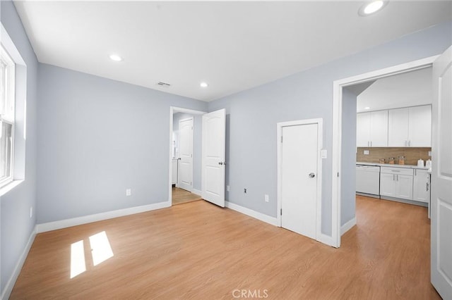 1223 W 90th St, Los Angeles, CA 90044 - unfurnished bedroom with baseboards, recessed lighting, light wood finished floors, and connected bathroom