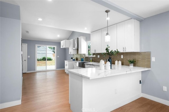 1223 W 90th St, Los Angeles, CA 90044 - kitchen with a sink, a peninsula, light stone counters, backsplash, and light wood-type flooring