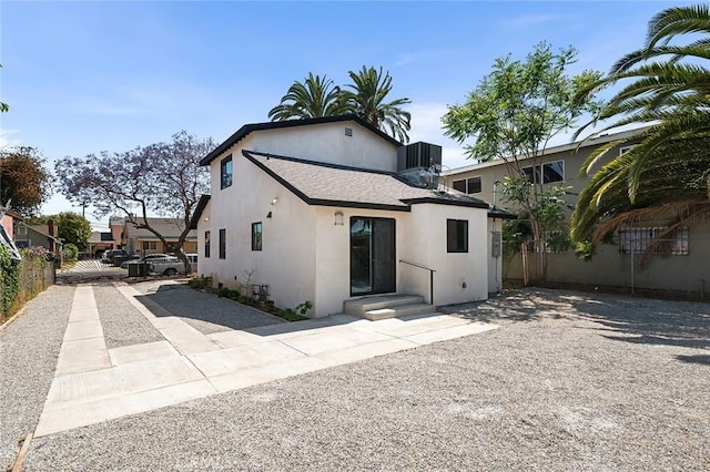 1223 W 90th St, Los Angeles, CA 90044 - back of house with gravel driveway, stucco siding, and cooling unit