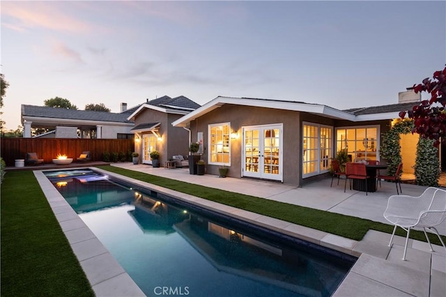 1307 Oxford Ln, Newport Beach, CA 92660 - back of house at dusk with french doors, a patio area, and stucco siding