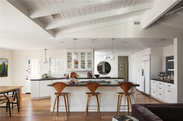 1307 Oxford Ln, Newport Beach, CA 92660 - kitchen with dark countertops, a center island, paneled fridge, a sink, and a kitchen bar