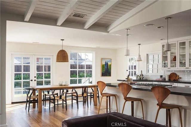 1307 Oxford Ln, Newport Beach, CA 92660 - kitchen with dark countertops, light wood-style floors, french doors, stainless steel gas cooktop, and beamed ceiling