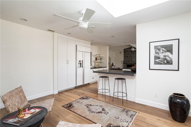 1307 Oxford Ln, Newport Beach, CA 92660 - kitchen featuring paneled built in fridge, dark countertops, light wood finished floors, and a kitchen breakfast bar