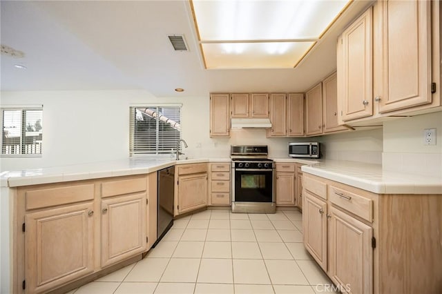 24177 Morning Dove Ln, Murrieta, CA 92562 - kitchen featuring range with gas cooktop, light brown cabinetry, dishwashing machine, stainless steel microwave, and tile countertops