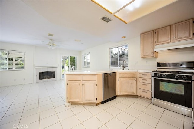 24177 Morning Dove Ln, Murrieta, CA 92562 - kitchen with range with gas cooktop, stainless steel dishwasher, light brown cabinetry, under cabinet range hood, and tile countertops